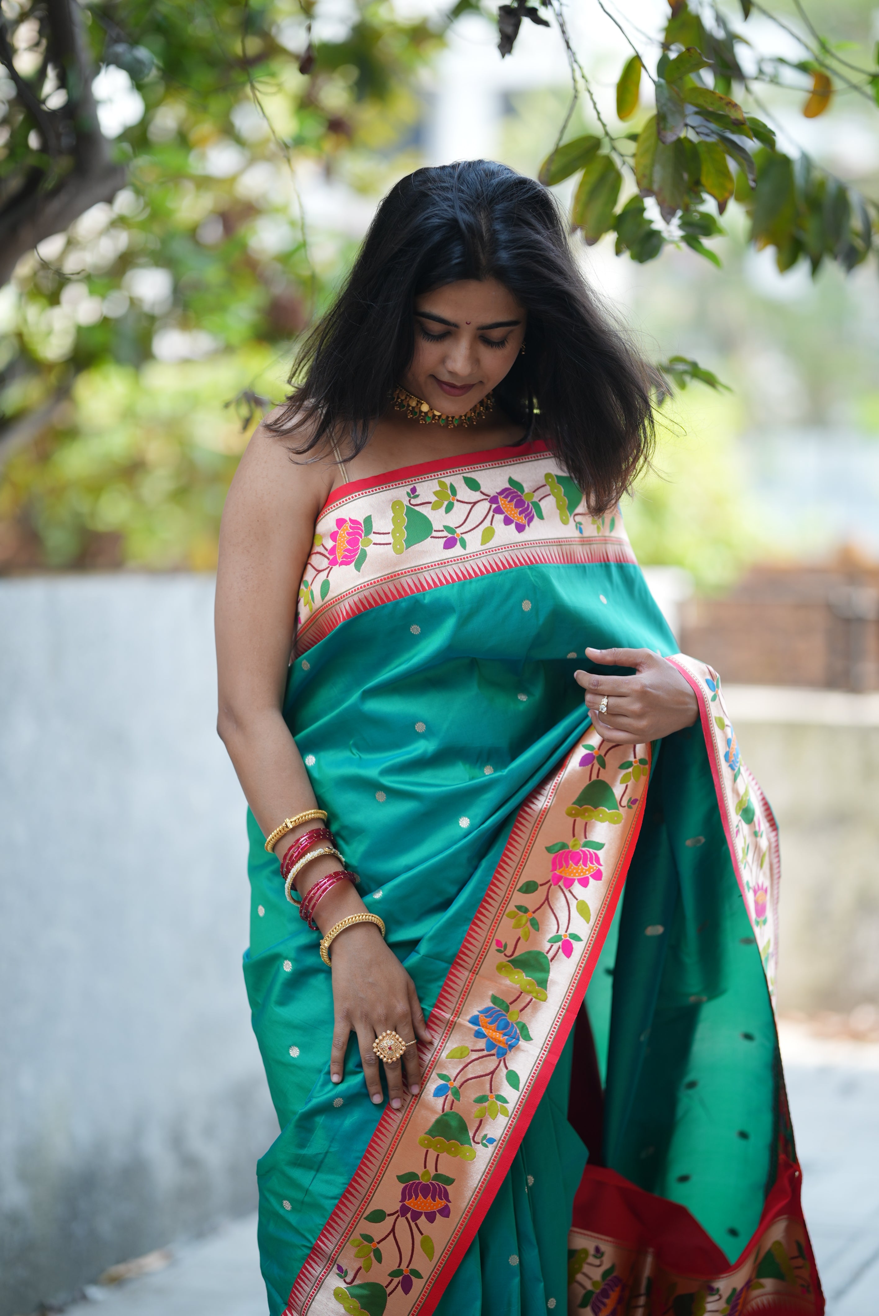 Teal green Paithani saree with a soft floral border and delicate zari buttas