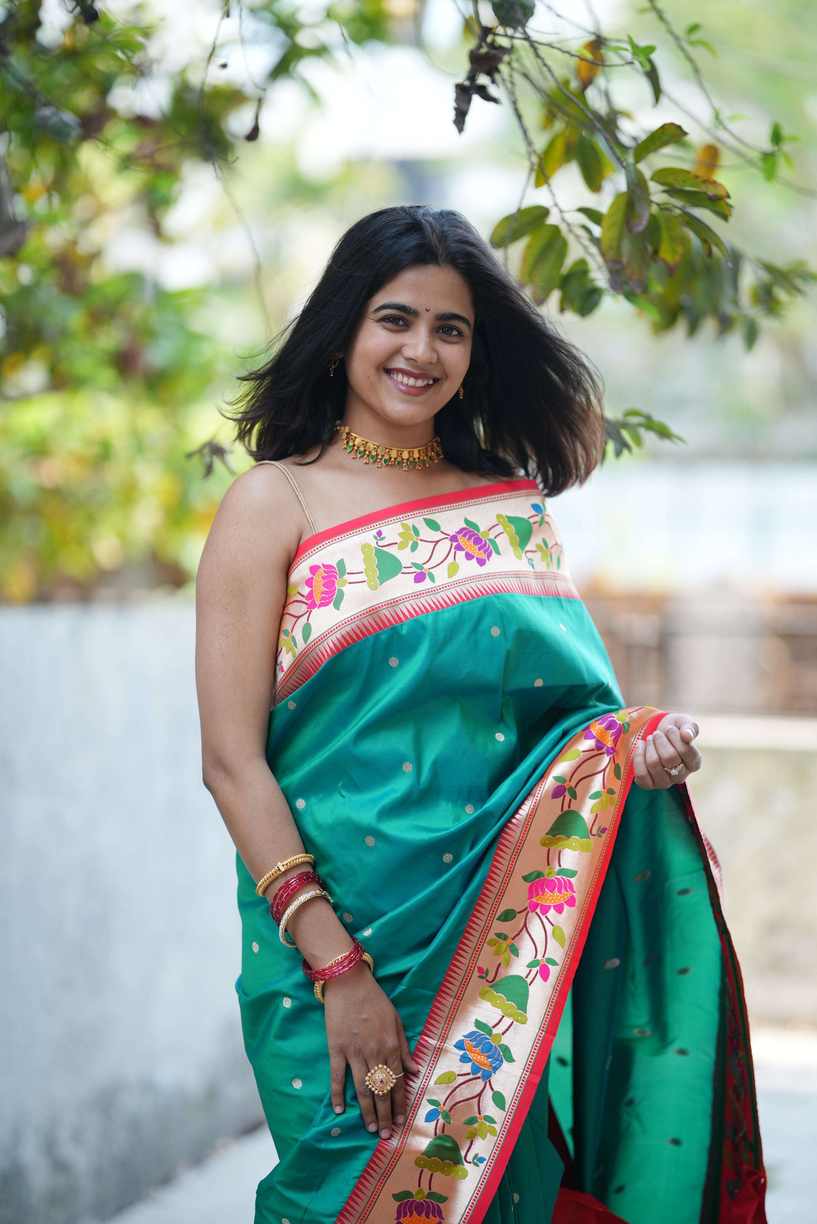 Teal green Paithani saree with a soft floral border and delicate zari buttas