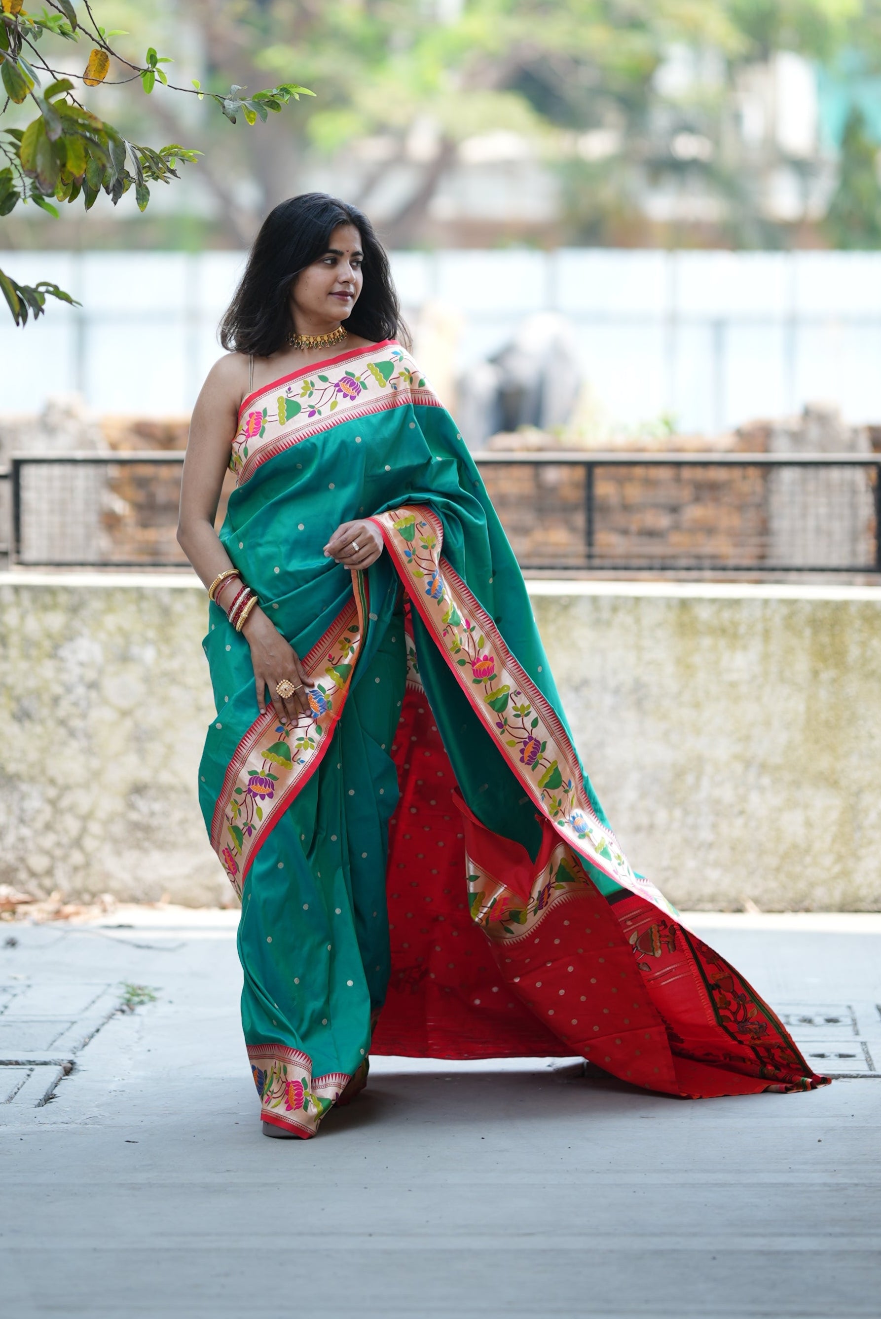 Teal green Paithani saree with a soft floral border and delicate zari buttas